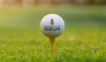 University of Guelph branded golf ball on a tee set against a blurred green background, promoting a university golf event.